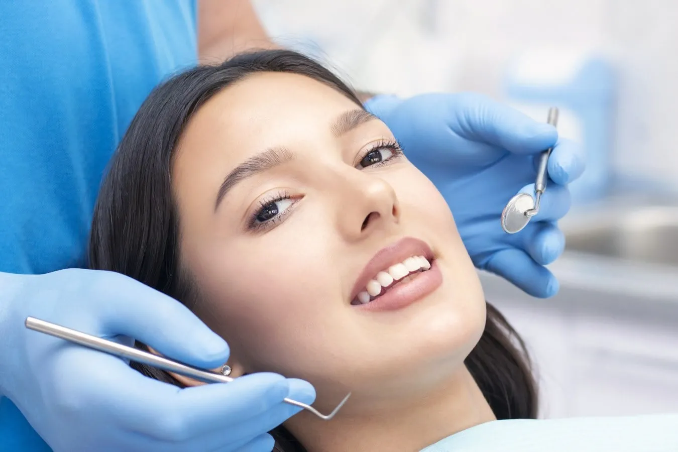 Smiling woman in dental chair receiving orthodontic care, showcasing benefits of adult braces at Garlock Orthodontics.
